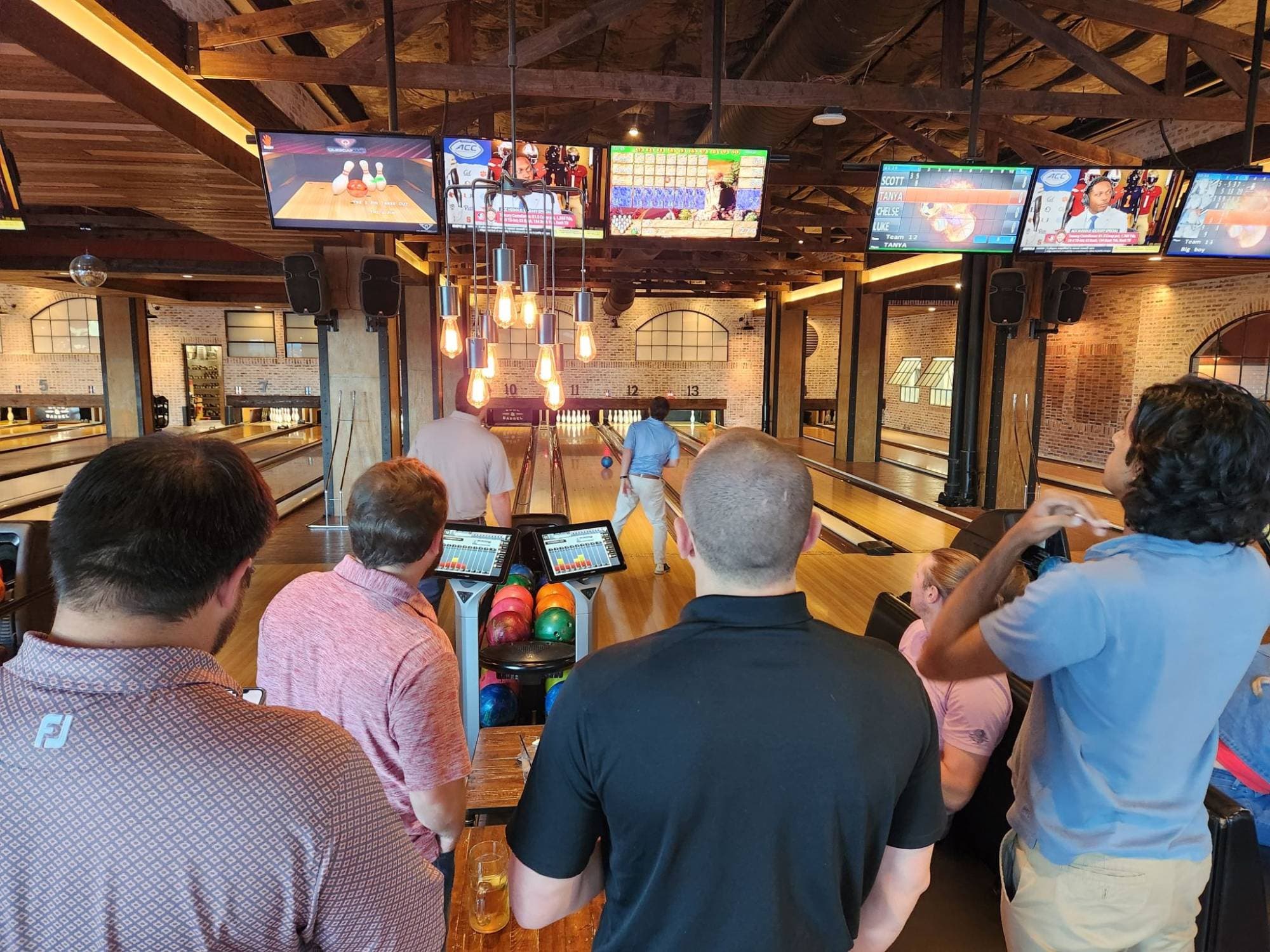 Watching a teammate roll a strike under the warm bulbs at Bowl & Barrel