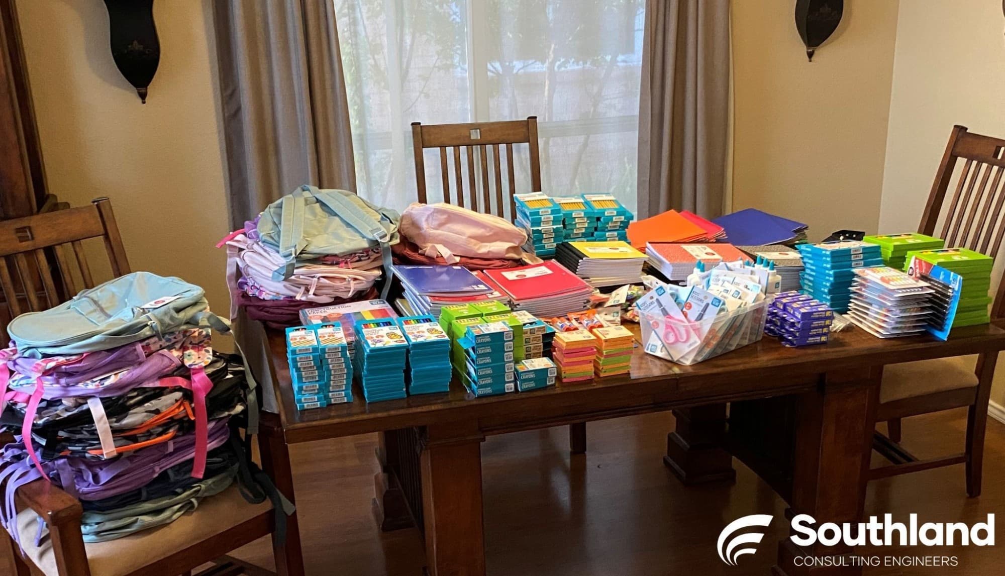 Backpacks lined up alongside notebooks, crayons, and folders — ready to ship to New Horizons in Abilene