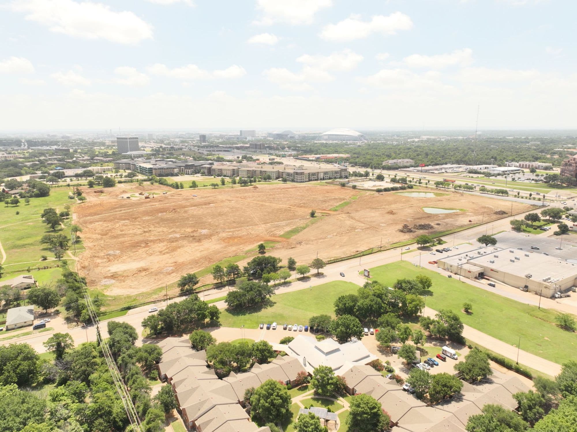 Wider aerial view showing the Rolling Hills development site with Arlington in the background and AT&T Stadium visible on the horizon