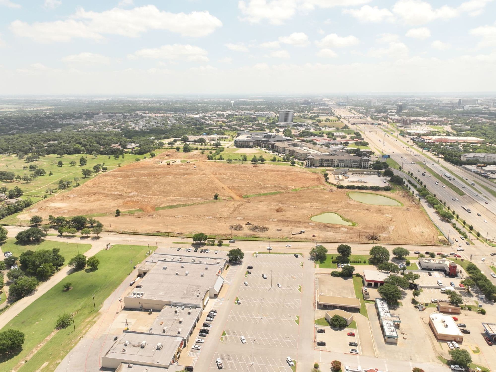 Third aerial view of the Rolling Hills site showing the graded land alongside detention features and the surrounding commercial corridor