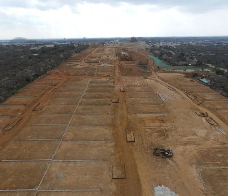 Rolling Hills construction progress — aerial view showing graded pads and utility trenches across the former golf course site